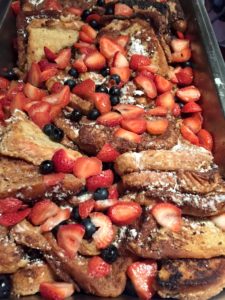 Deep fried French toast topped with strawberries and blueberries